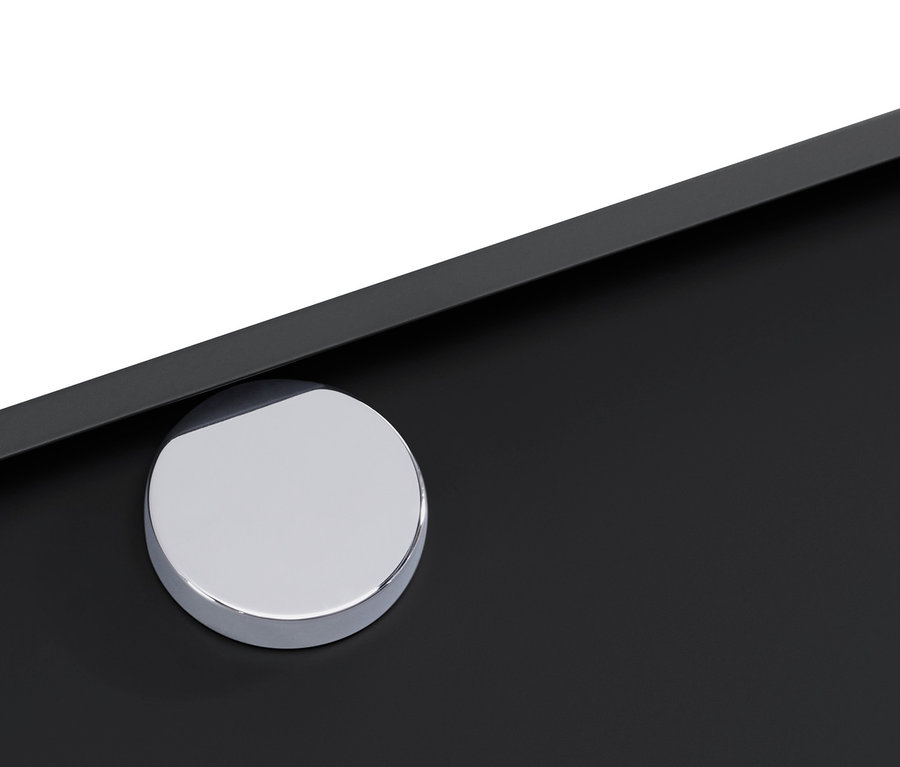 A fekete CN3 komód részlete, kerek, ezüst színű fogantyúval.