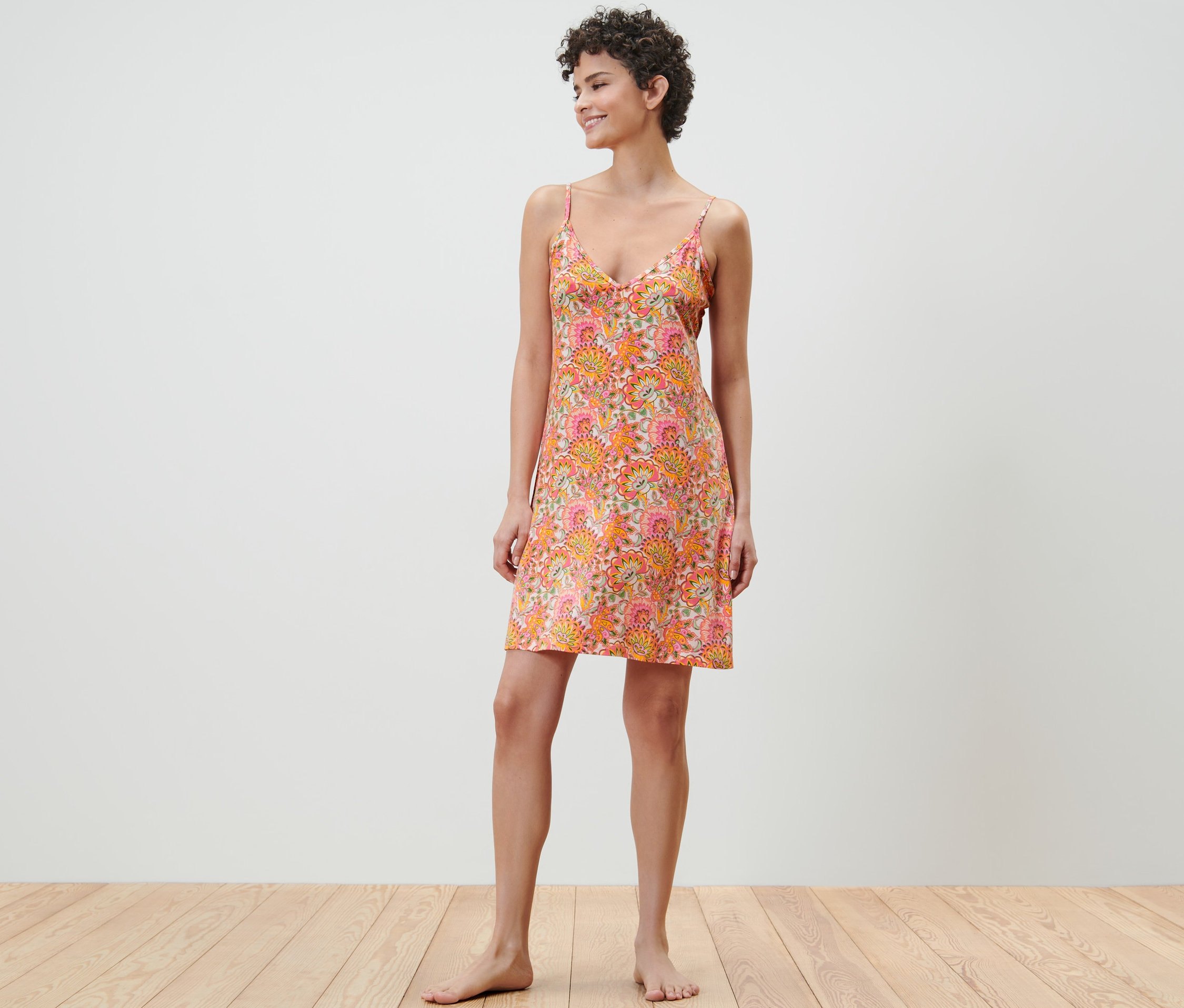 Nő áll virágmintás pántos hálóingben.