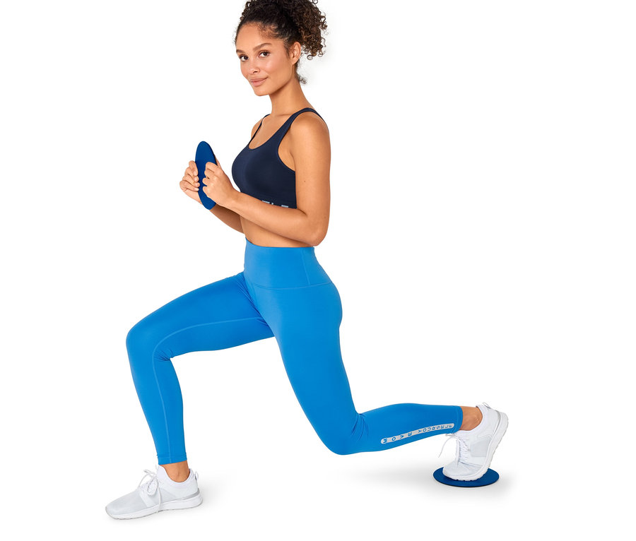 Nő kitörést végez 2 csúszókorong segítségével.