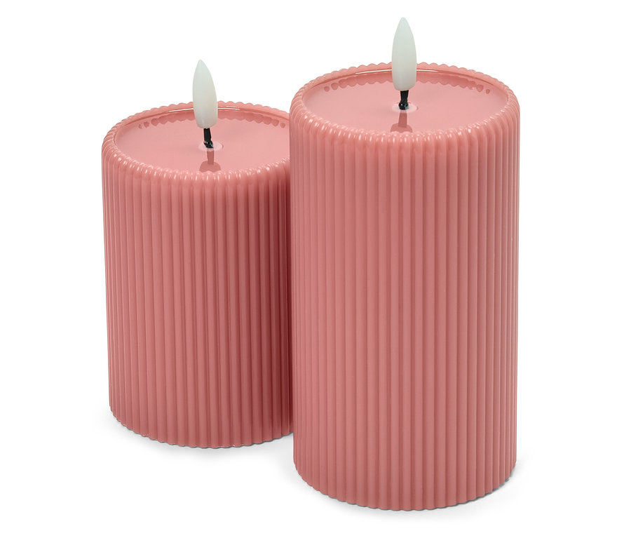 Két rózsaszín oszlopos gyertya bordázott felülettel és LED lángokkal.