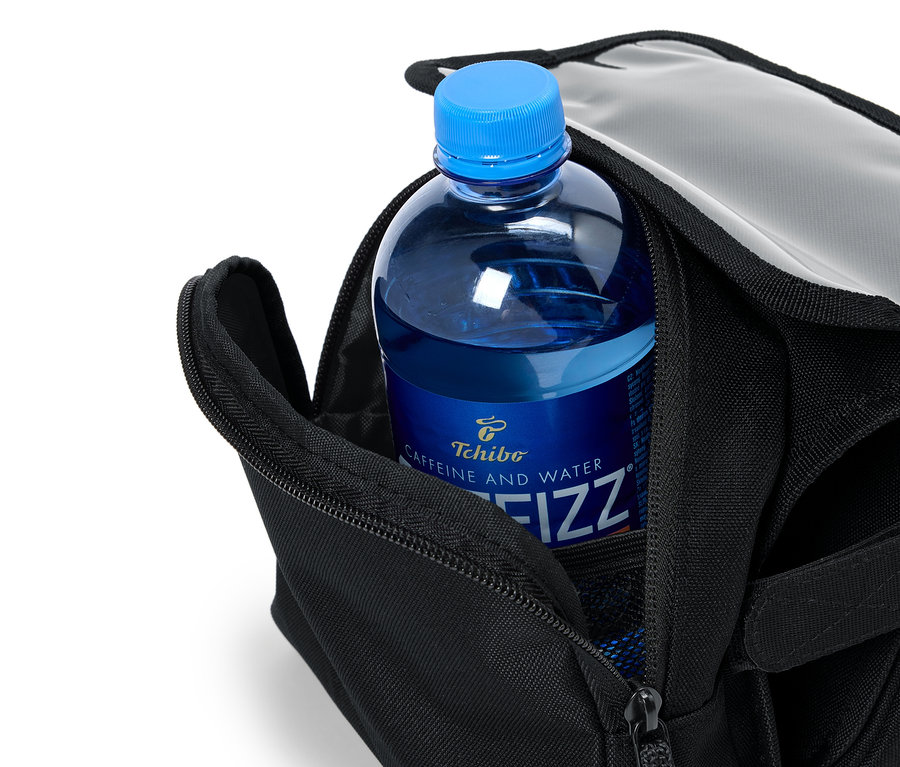 Egy kék Tchibo Caffeine and Water Fizz üveg van egy nyitott fekete táskában.
