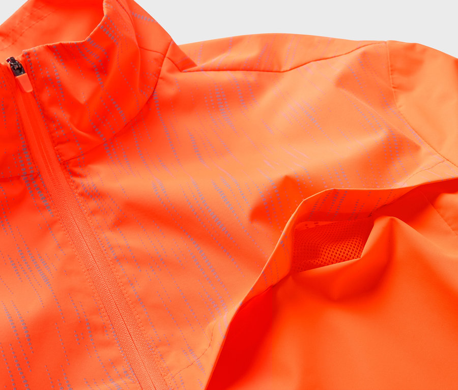 Narancssárga cipzáras kabát részletgazdag felvétele, zsebbel.