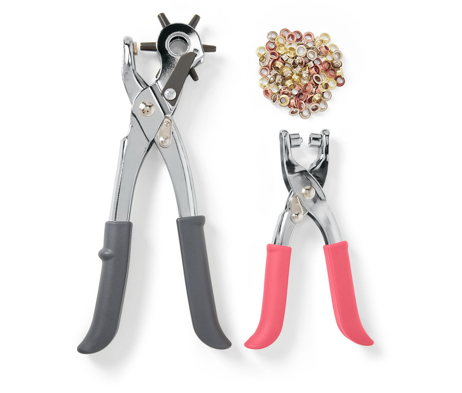 Két lyukasztófogó és szegecsek fehér háttéren.