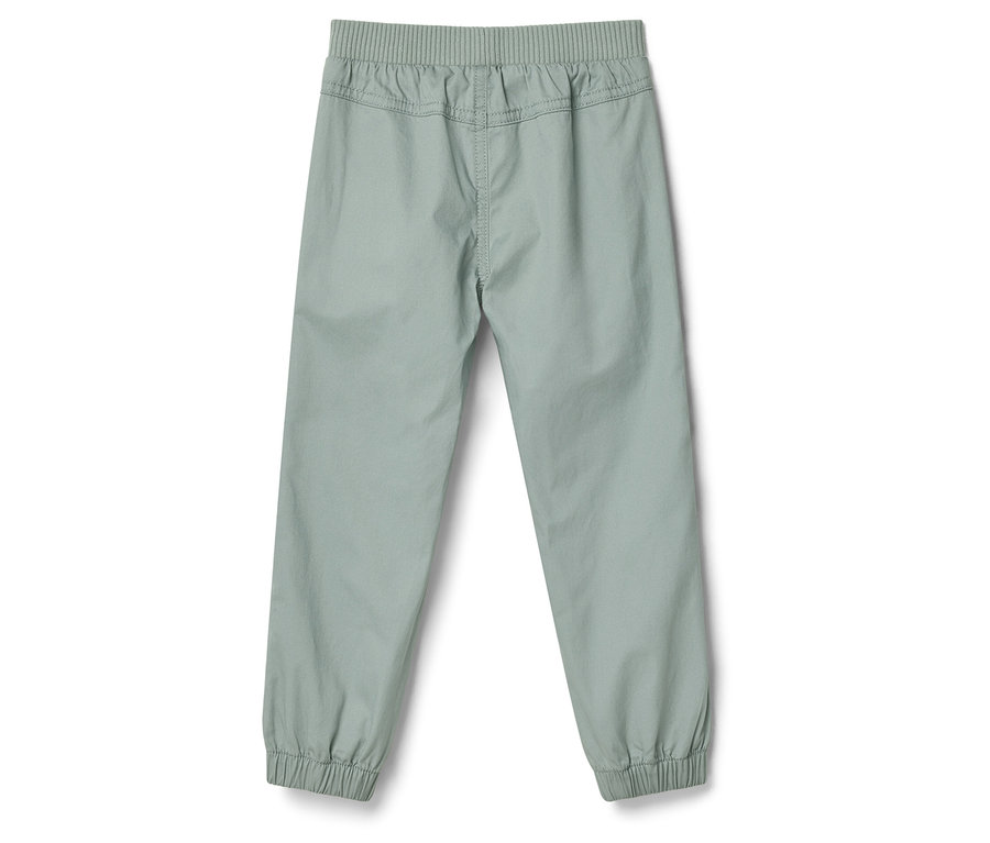 Világos nadrág gumis derékkel és bokánál passzés szárral, hátulról fényképezve.