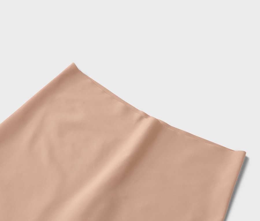 Egy barack színű, egyszínű szövet közeli képe.