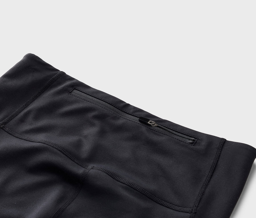 Közelkép egy fekete leggings cipzáras zsebéről.