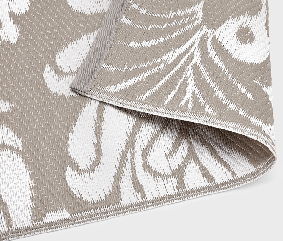 Egy kültéri szőnyeg közeli képe szürke és fehér mintával.