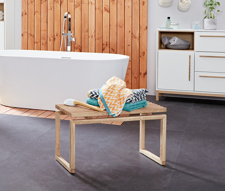 Fürdőszobabelső mosdó alatti szekrénnyel, törölközőtartó létrával és jacquard fürdőlepedőkkel.