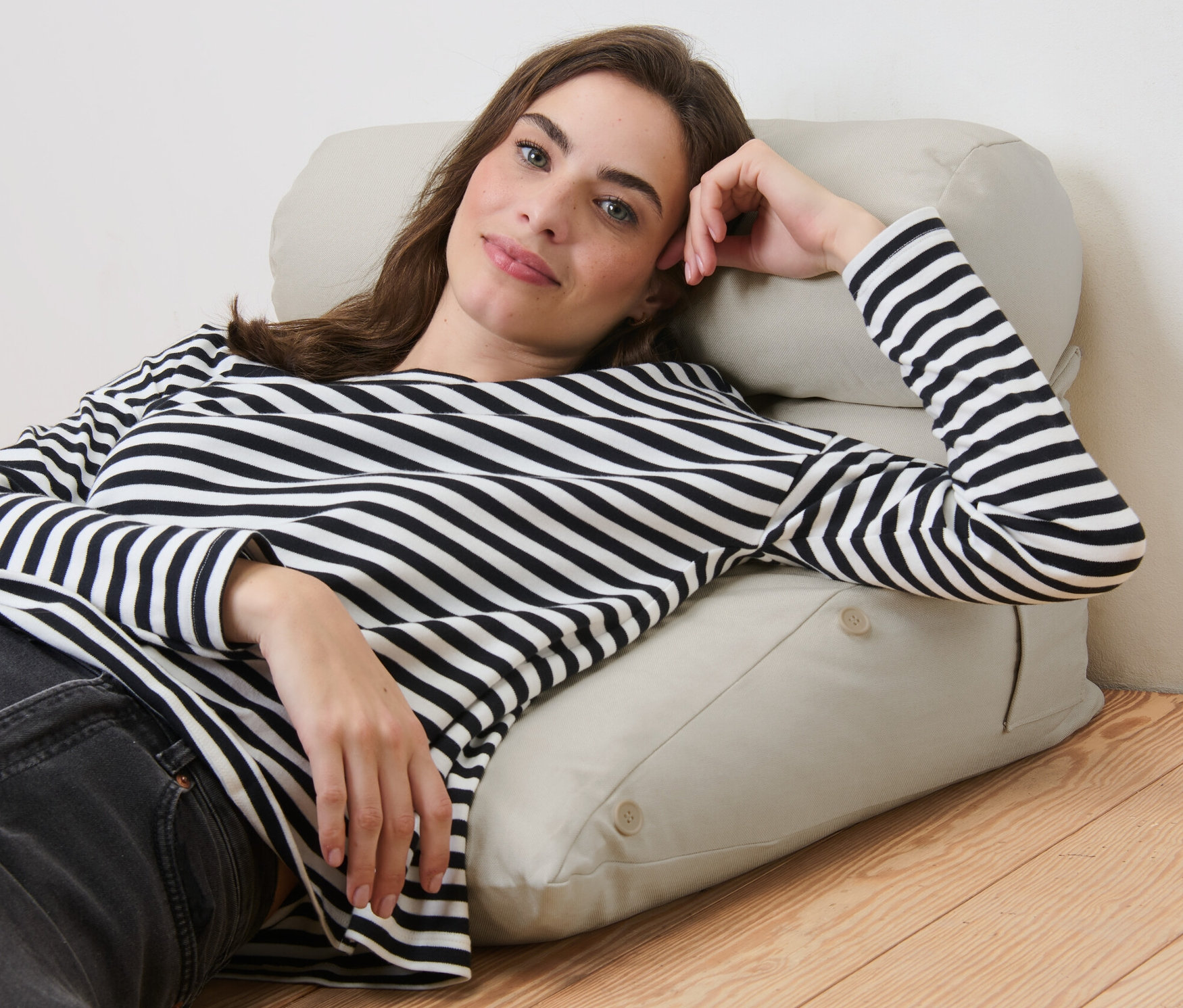 Nő fekszik egy ékpárnán.