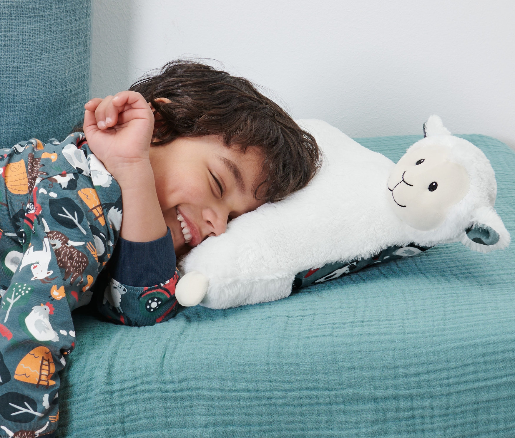 Fiú alszik a párna bárányos mintával és pizsamatároló füllel.