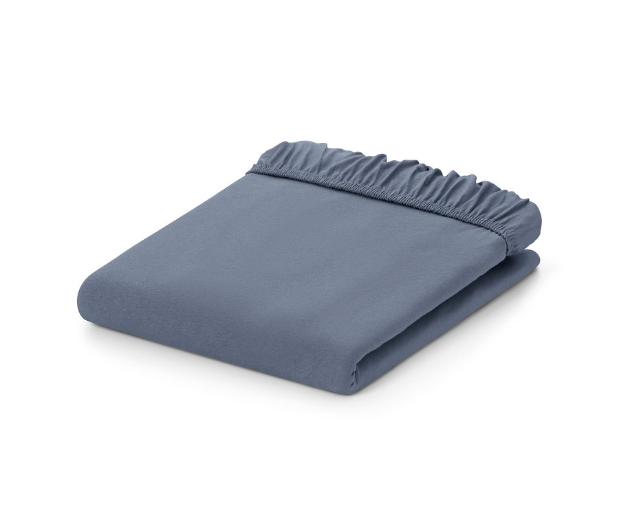 Egy összehajtott kék gumis jersey lepedő.