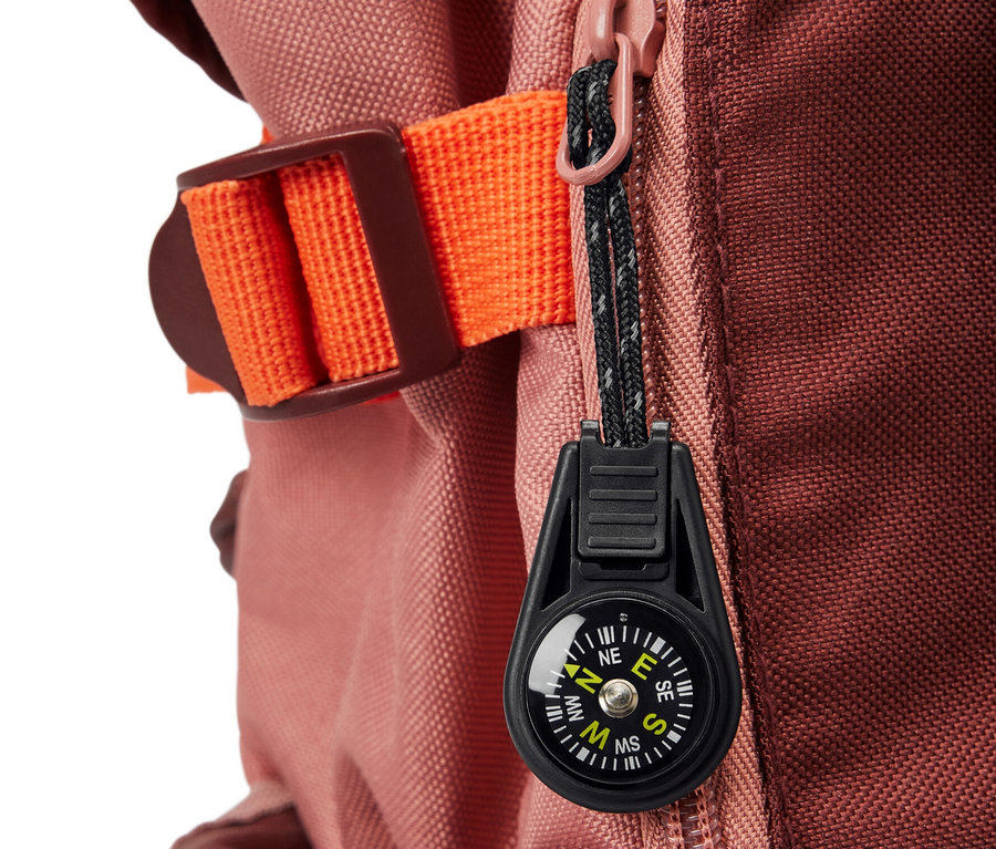 Egy hátizsák részlete, rajta egy cipzárra akasztható iránytű.