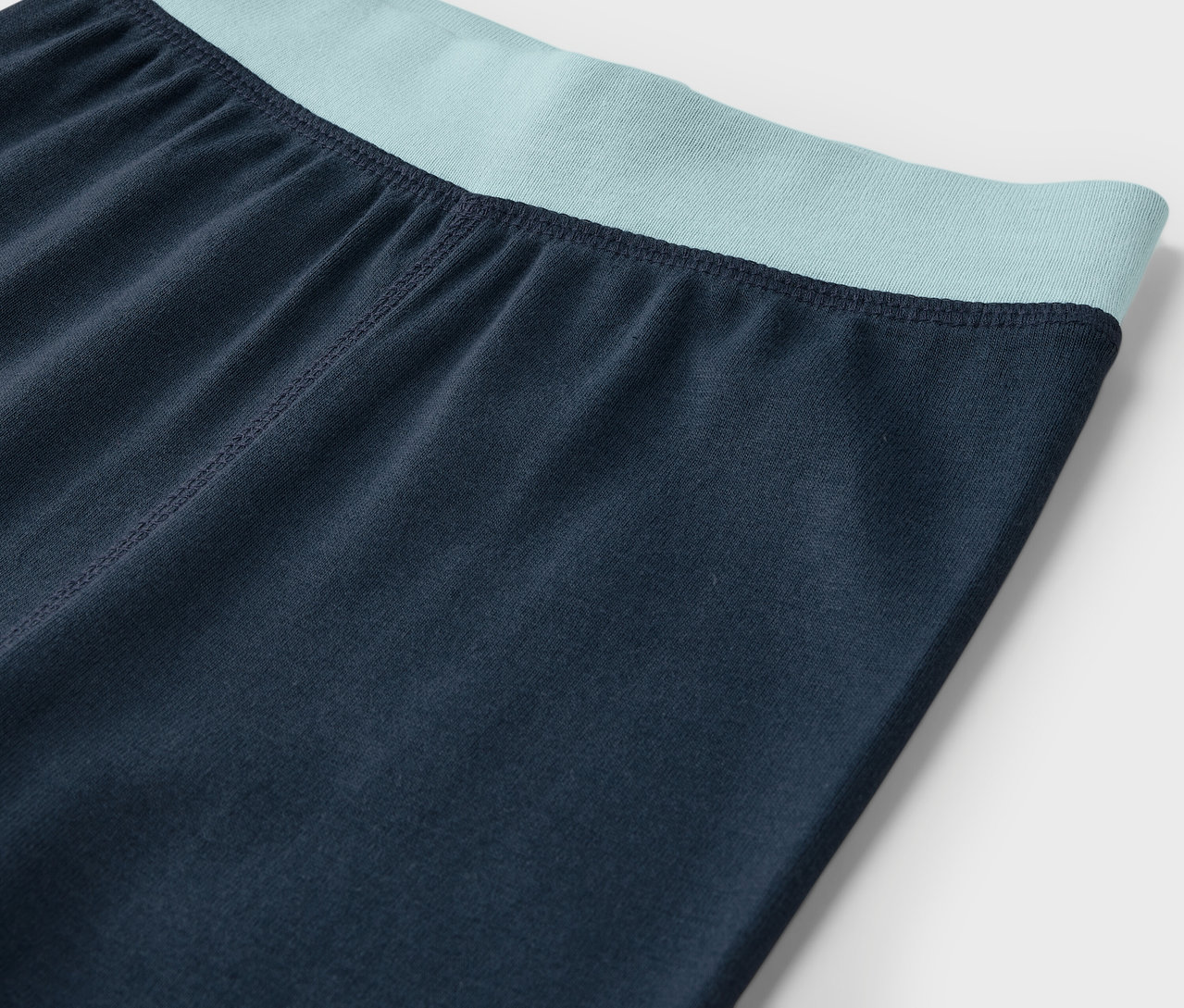 Sötétkék leggings részlete mentazöld derékpánttal.