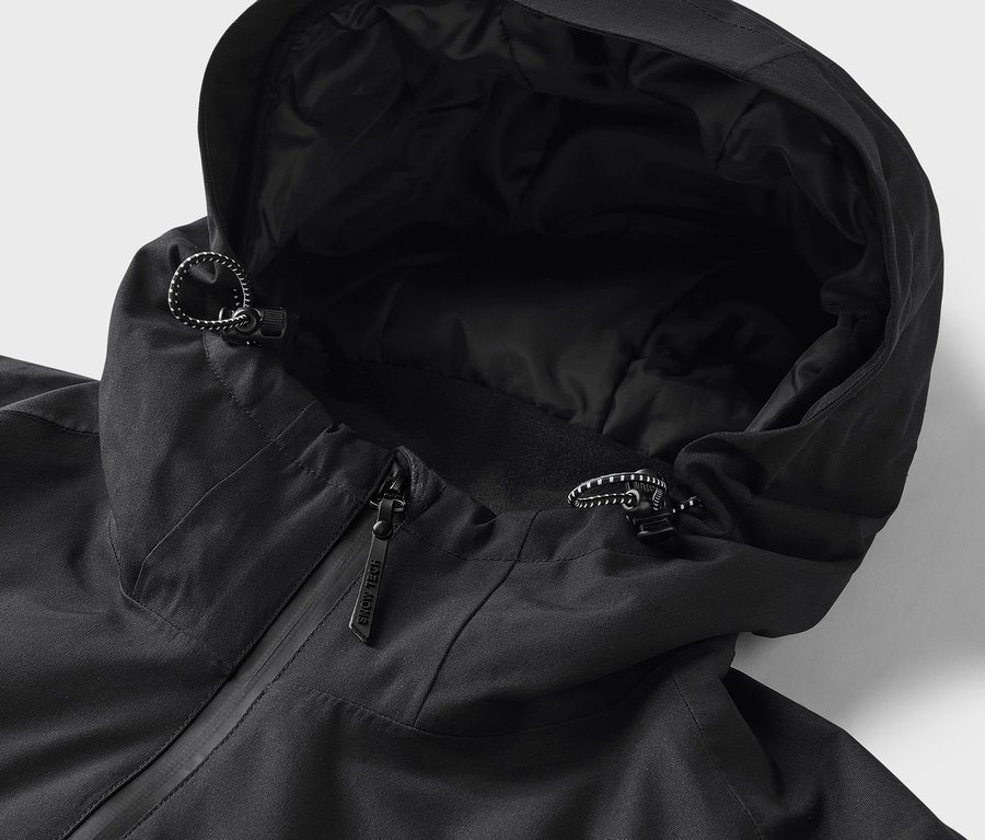 Egy fekete kapucnis dzseki részlete közelről, húzózsinórral.