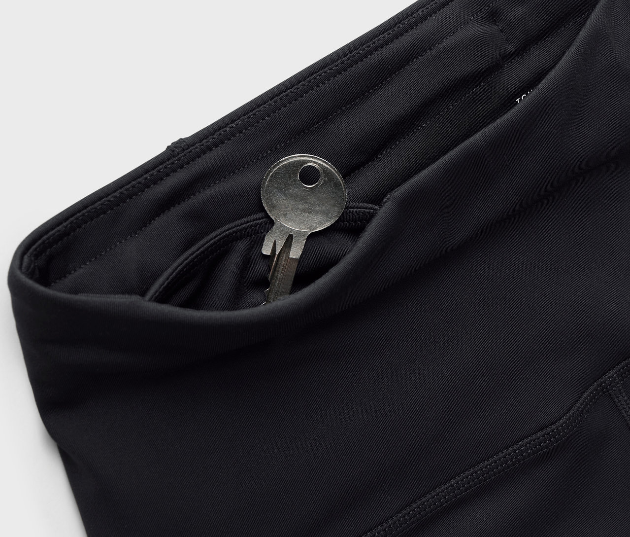 Fekete leggings kulccsal a zsebben.