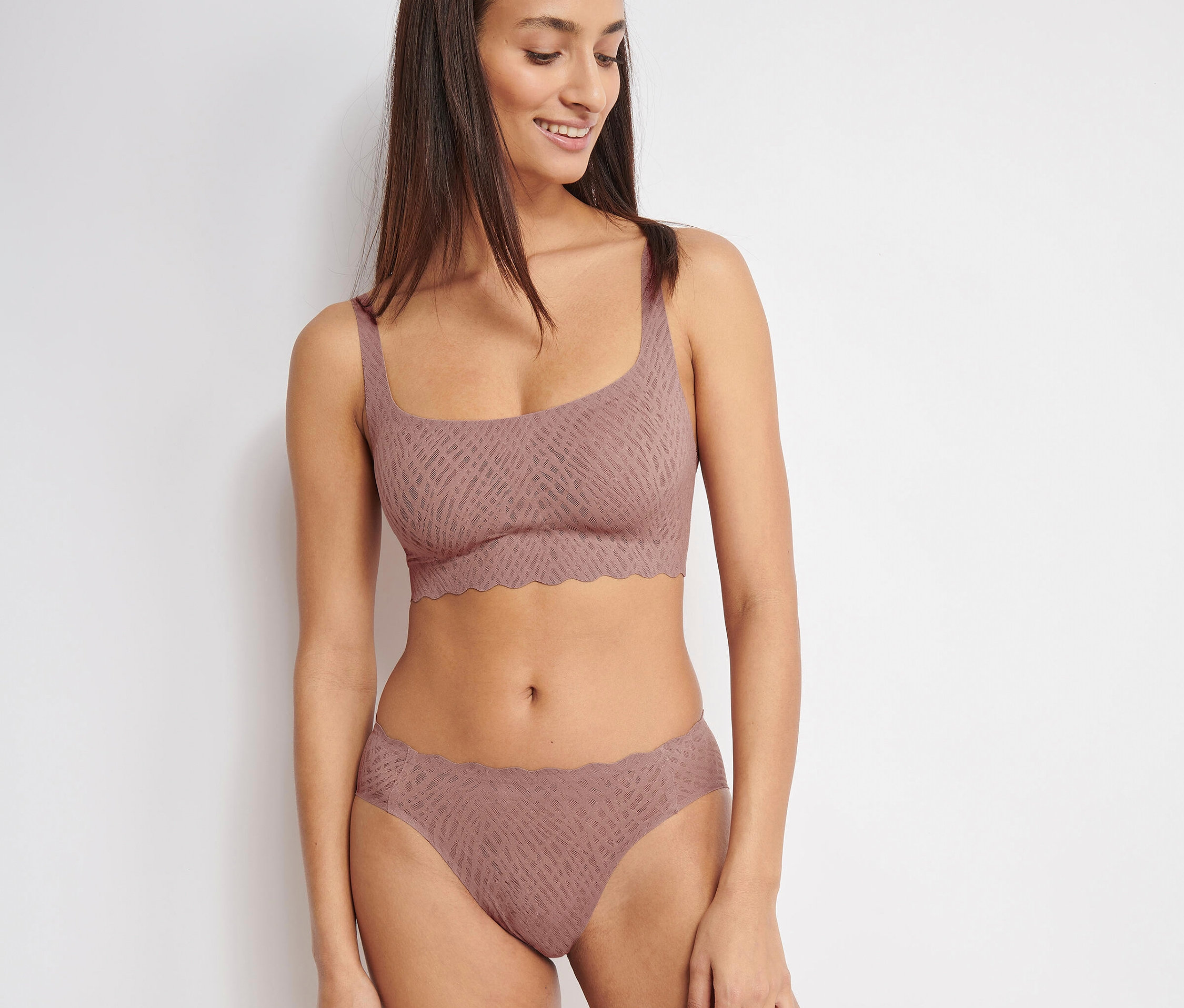 Nő visel kakaó színű sloggi ZERO Feel Bliss felsőt és alsót.