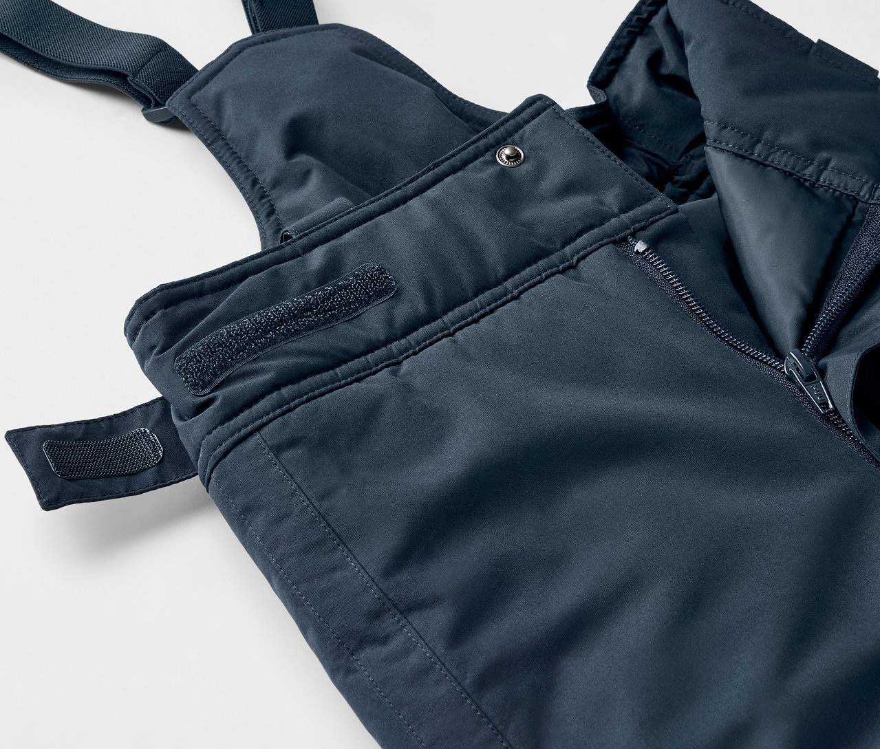 Kék kantáros nadrág részlete cipzárral és tépőzárral.