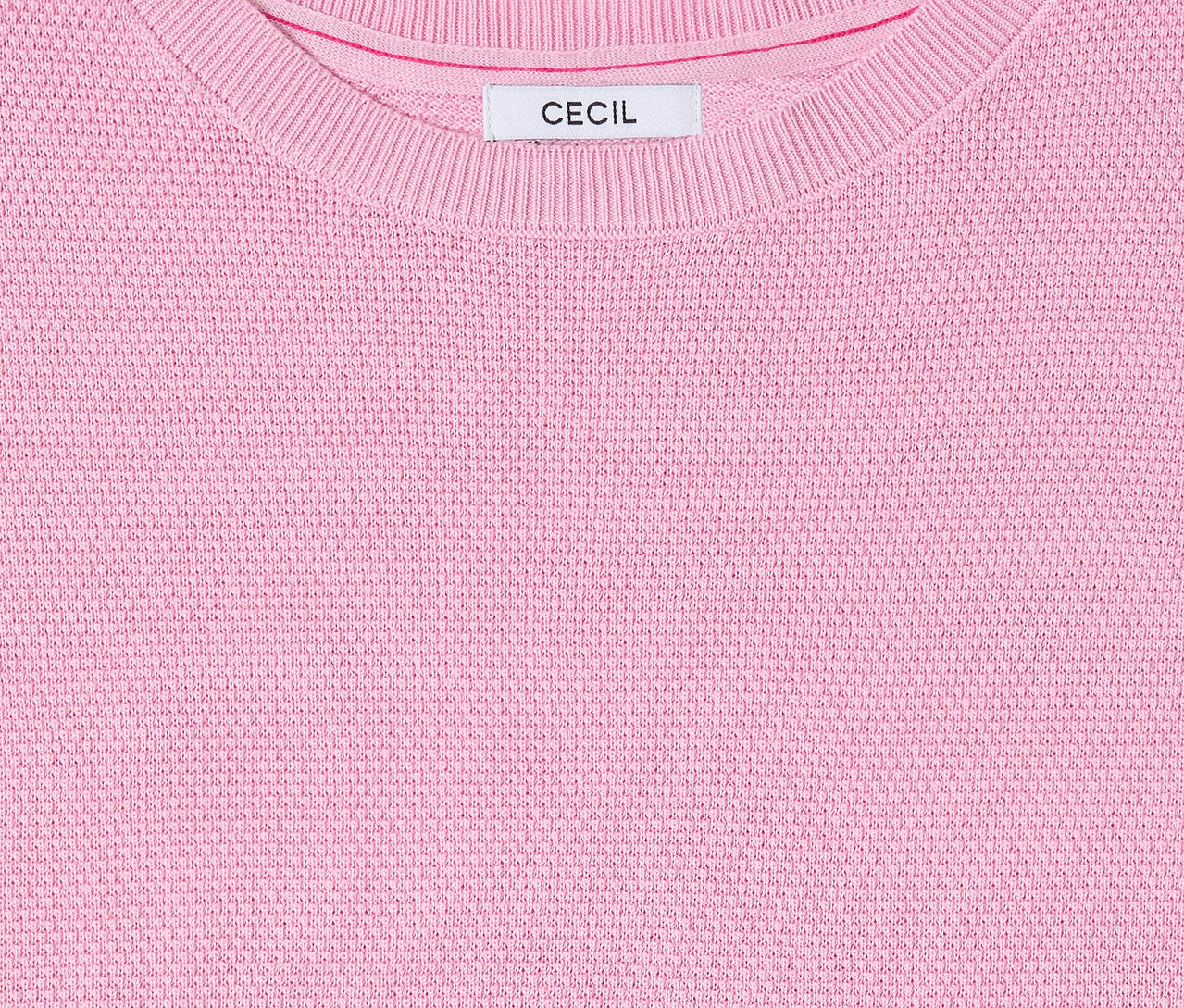Közelkép a rózsaszín, kerek nyakú, címkés CECIL rövid ujjú pulóverről.