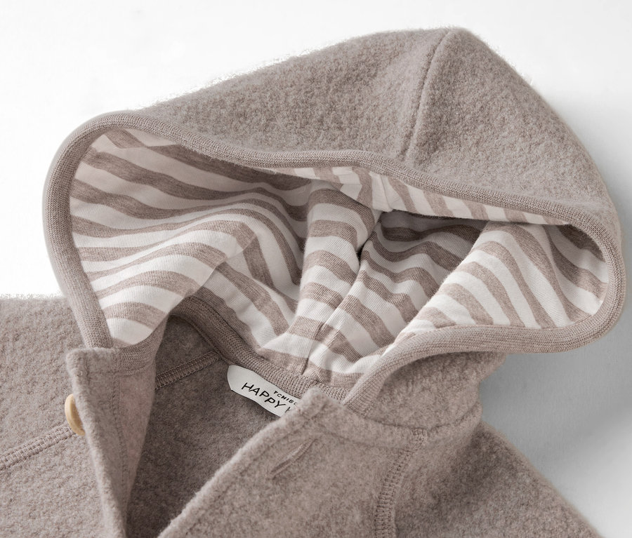 Egy bézs gyapjúszövet kapucni közeli képe bézs és fehér csíkos béléssel.