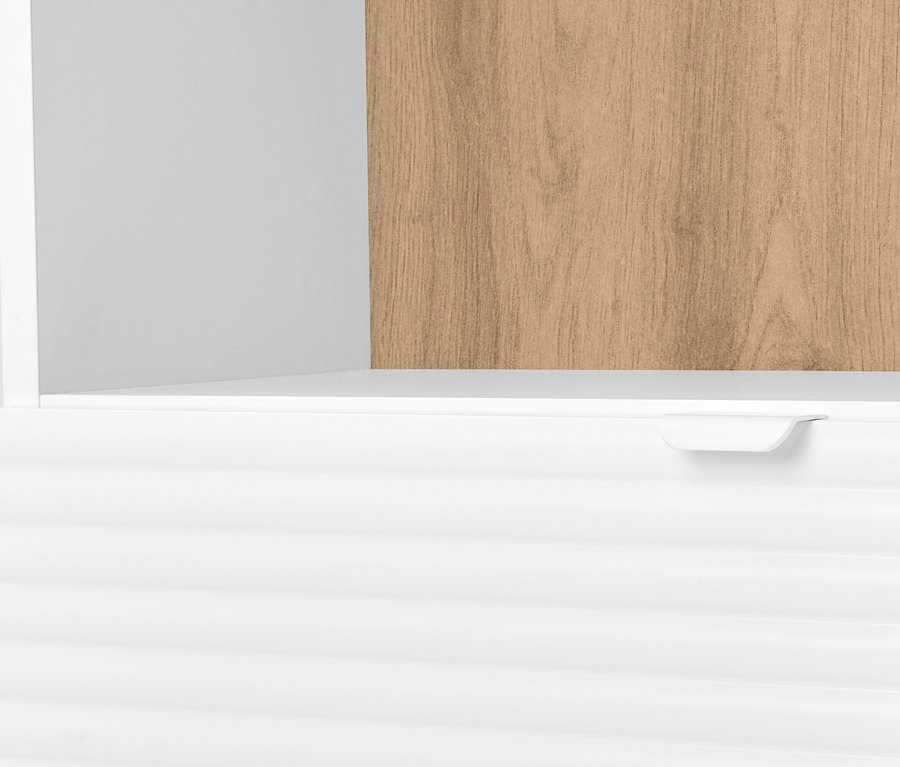 Egy fehér szekrény részletfotója fiókkal és fa polccal.