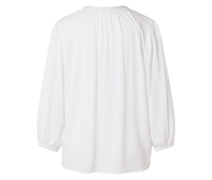 Hátulnézet egy fehér, hosszú ujjú blúzról.