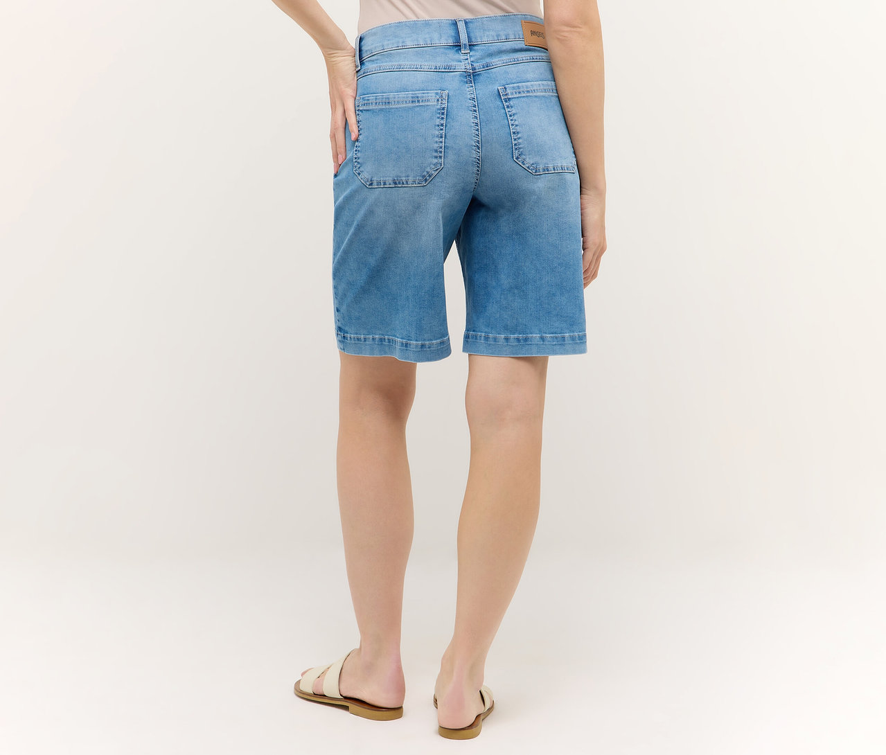 Hátulnézet egy kék Angels Denim »Lia Urban« rövidnadrágot és szandált viselő nőről.