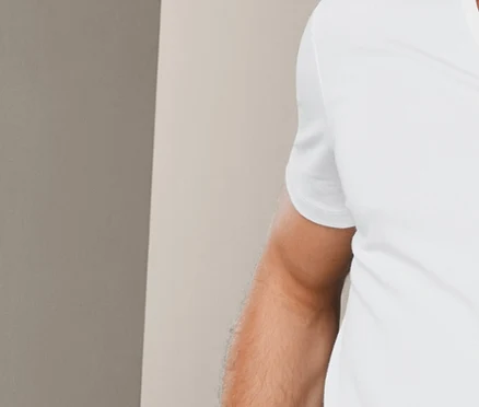 Egy falnak dőlő férfi fehér V-nyakú pólót és kockás boxeralsót visel. Rajta egy 2 férfi V-nyakú póló szettben, fehér.