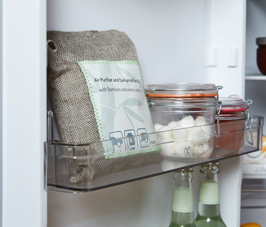 A hűtőszekrényben, egy átlátszó rekeszben található egy légtisztító és páramentesítő tasak, üvegek mellett, fedőkkel.