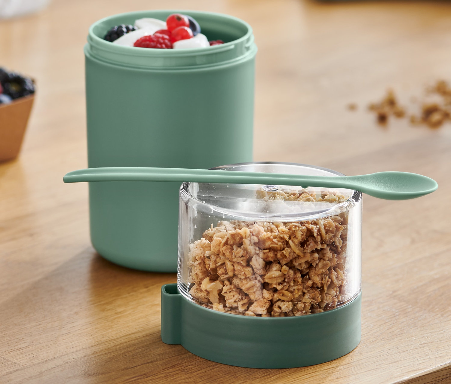 Egy to-go joghurtos pohár müzlivel és gyümölcsökkel látható.