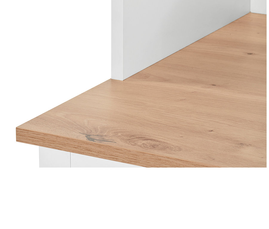 Egy fehér, oldalsó peremmel ellátott írókomód részlete.