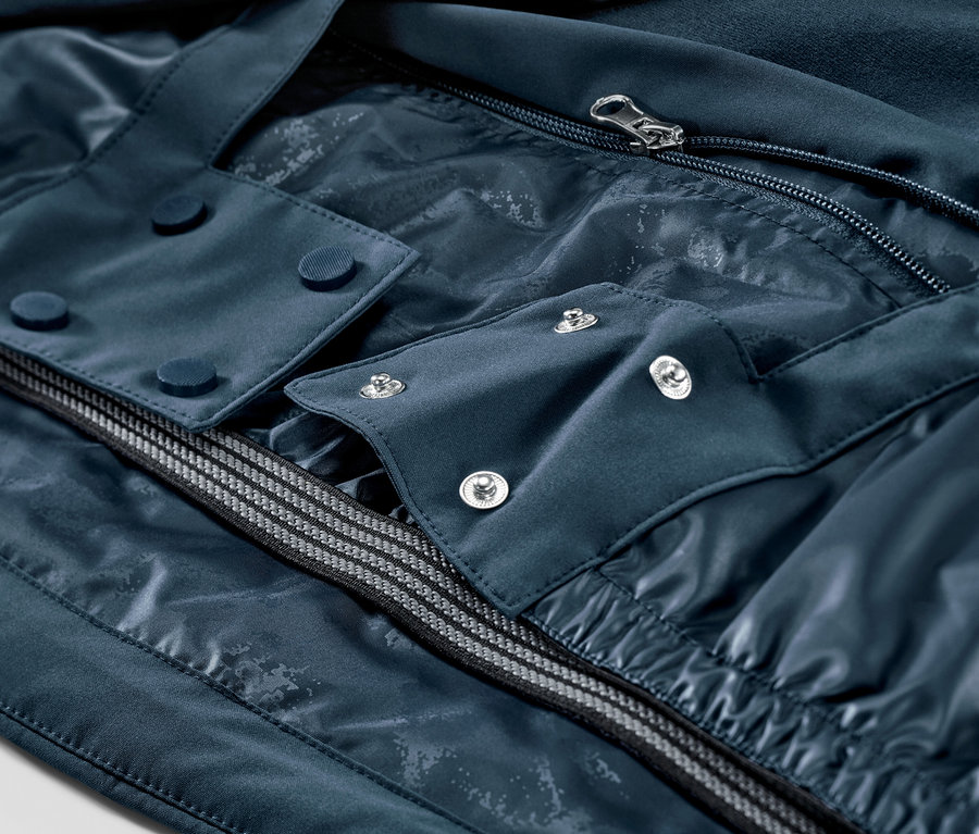 Egy tengerészkék síkabát részlete cipzárral és gombokkal.