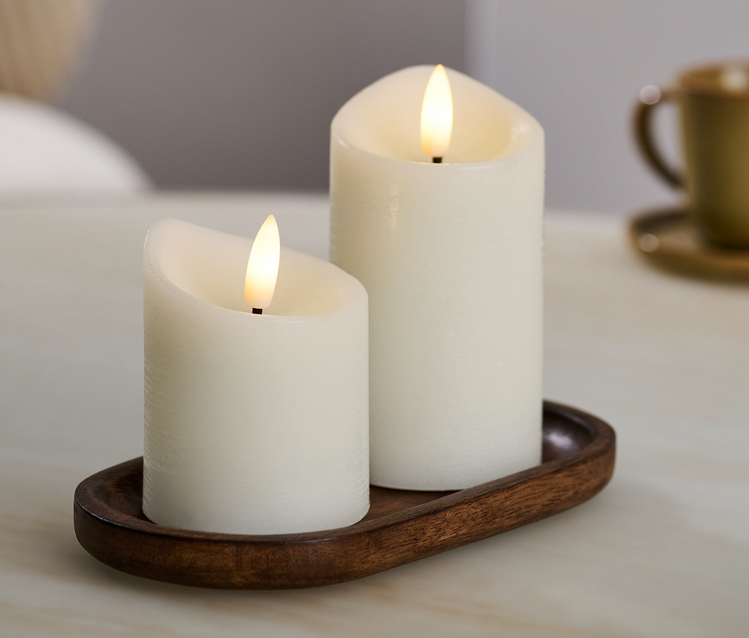 Két krémszínű LED-es valódi viaszgyertya egy barna tálcán.