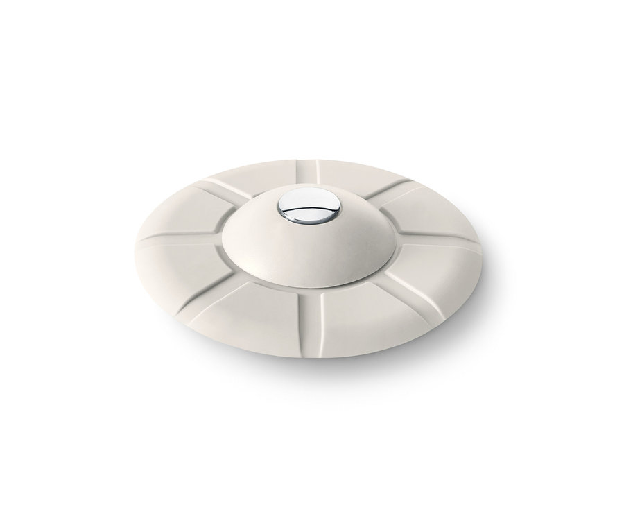 Egy bézs színű 2 az 1-ben lefolyószűrő és dugó fehér háttérrel.