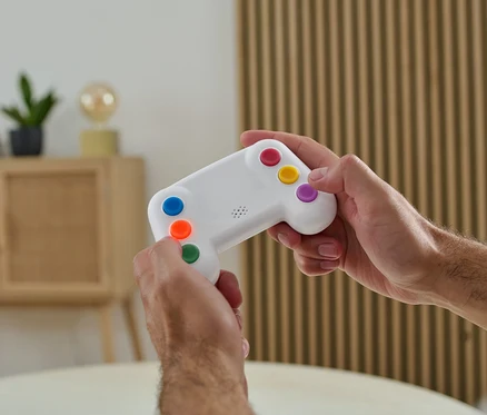 Egy férfi színes gombokkal ellátott elektronikus memóriajátékot tart a kezében.