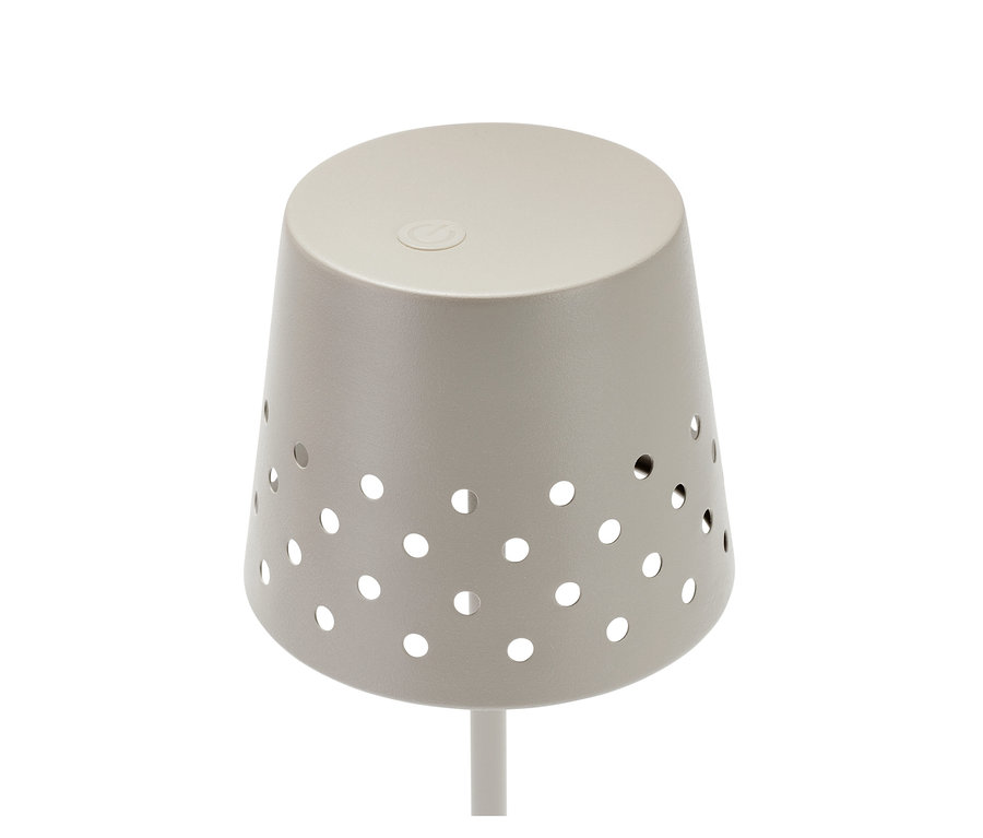 Egy fémből készült LED-es, akkus állólámpa részlete, kerek lyukakkal.