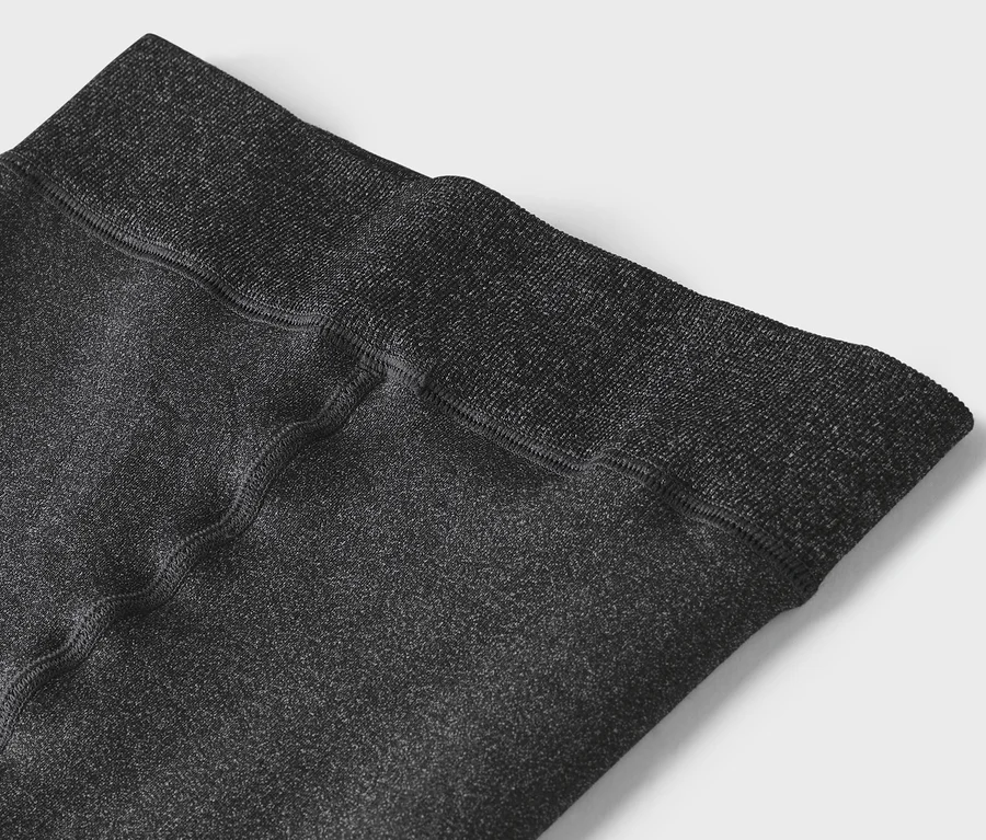 Közelkép egy szürke leggings derékrészéről.