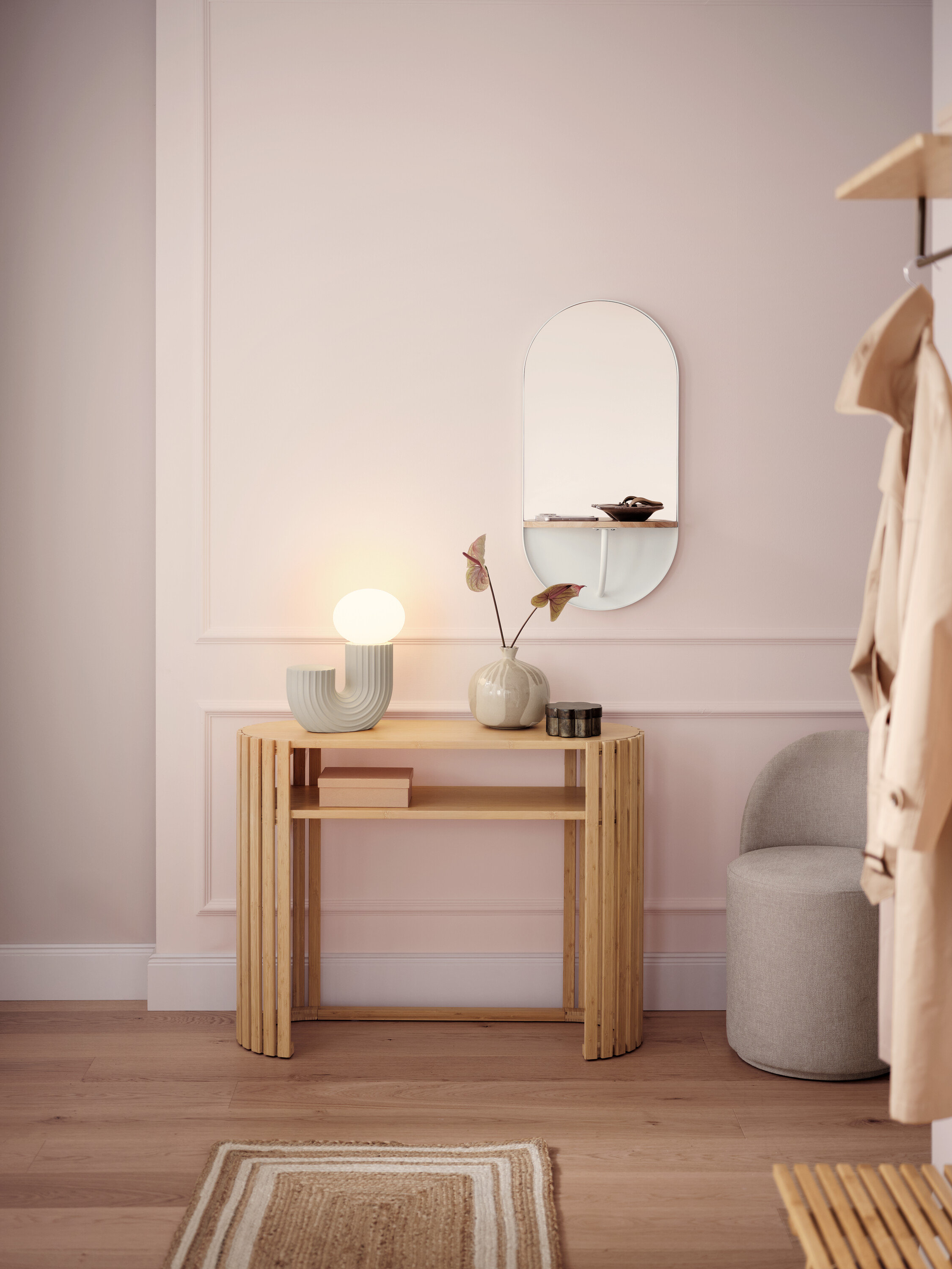 Világos előszoba fa konzolasztallal, lámpával, tükörrel és szürke székkel.