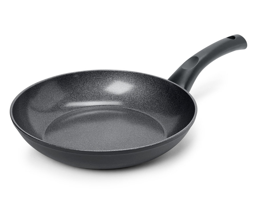 Egy fekete serpenyő közeli képe texturált felülettel, fehér háttérrel.