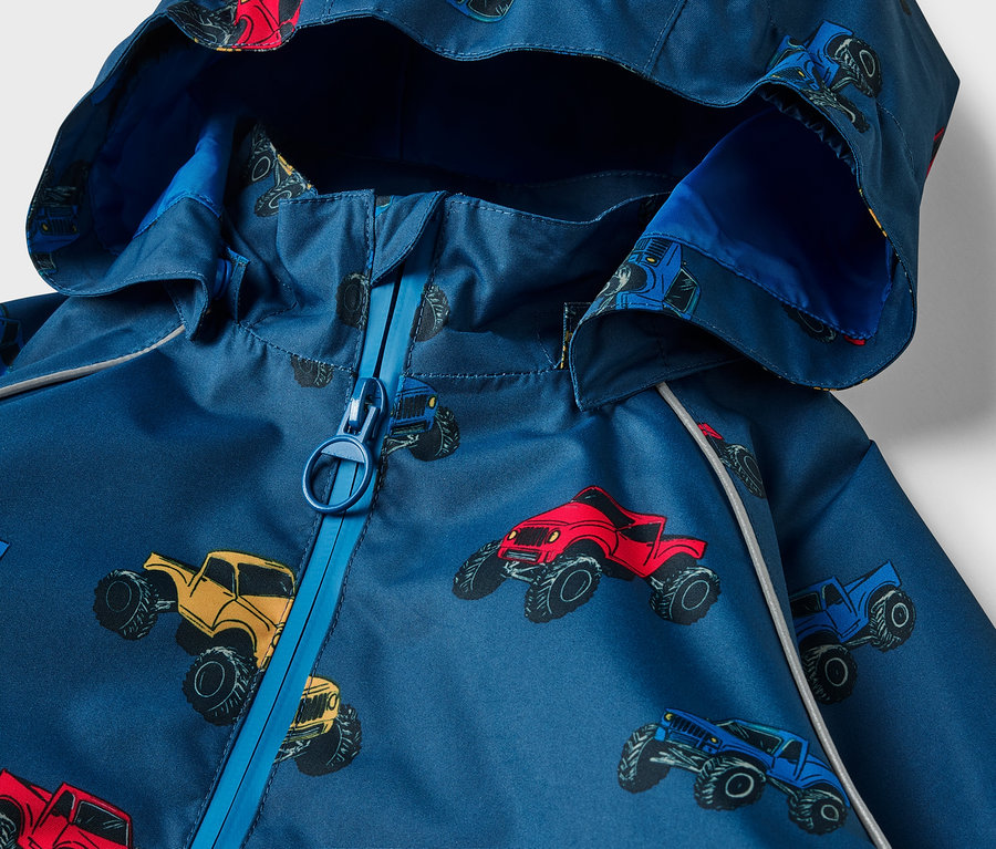 Egy gyermek termo esőkabát részlete, Monster Truck terepjáró-mintás.