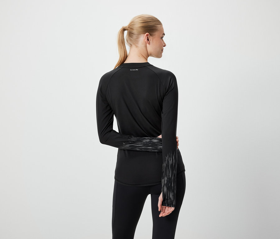 Hátulról látható szőke nő lófarokkal, fekete sportruházatban.