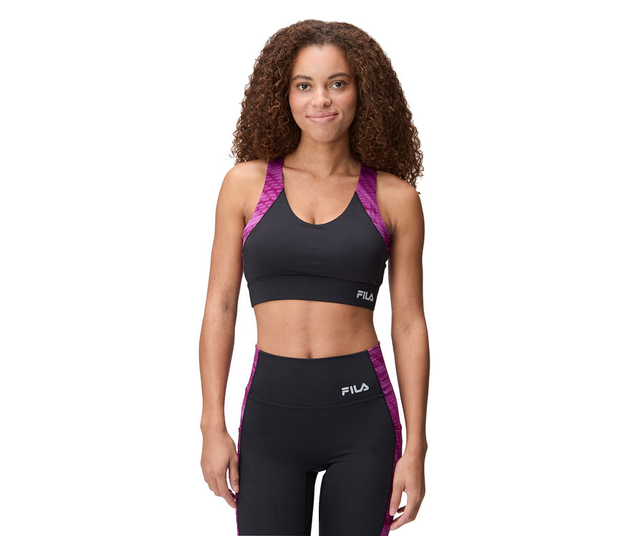 Nő visel fekete Fila sportmelltartót lila részletekkel és hozzáillő leggingset.
