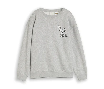 Szürke pulóver fekete körvonalas rajzzal, amelyen ülő Snoopy néz fel a felette repülő Woodstockra.