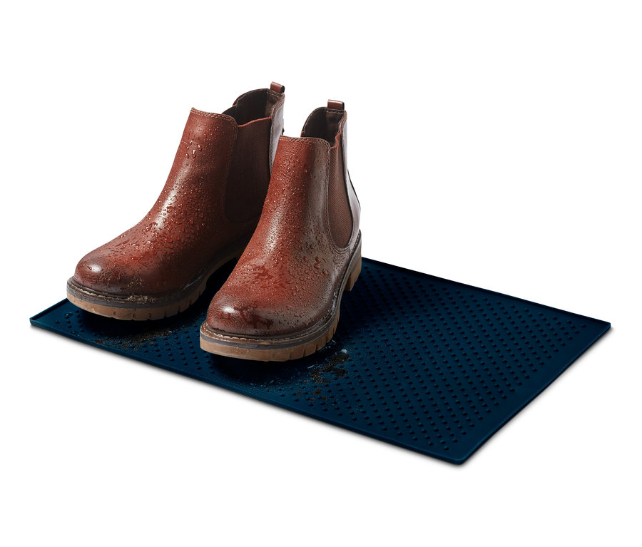 Két barna bőr csizma áll egy kék alátét etetőtálhoz.