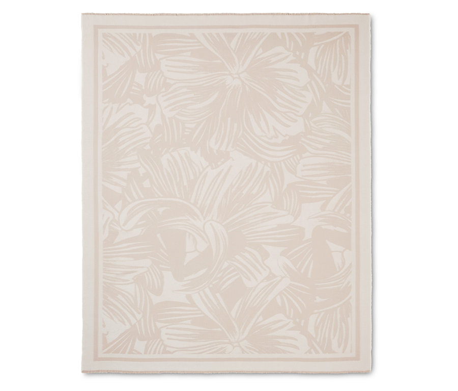 Krémszínű takaró virágmintával és szegéllyel.