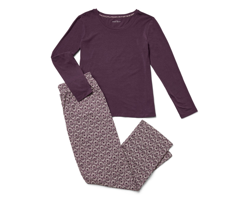 Egy lila, hosszú ujjú pizsama és egy virágos nadrág fekszik egy fehér háttéren.