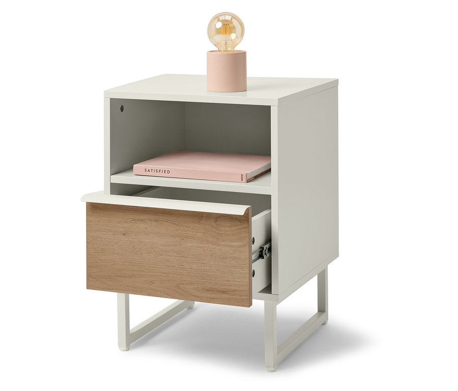 Fehér éjjeliszekrény fa fiókkal és rózsaszín lámpával.