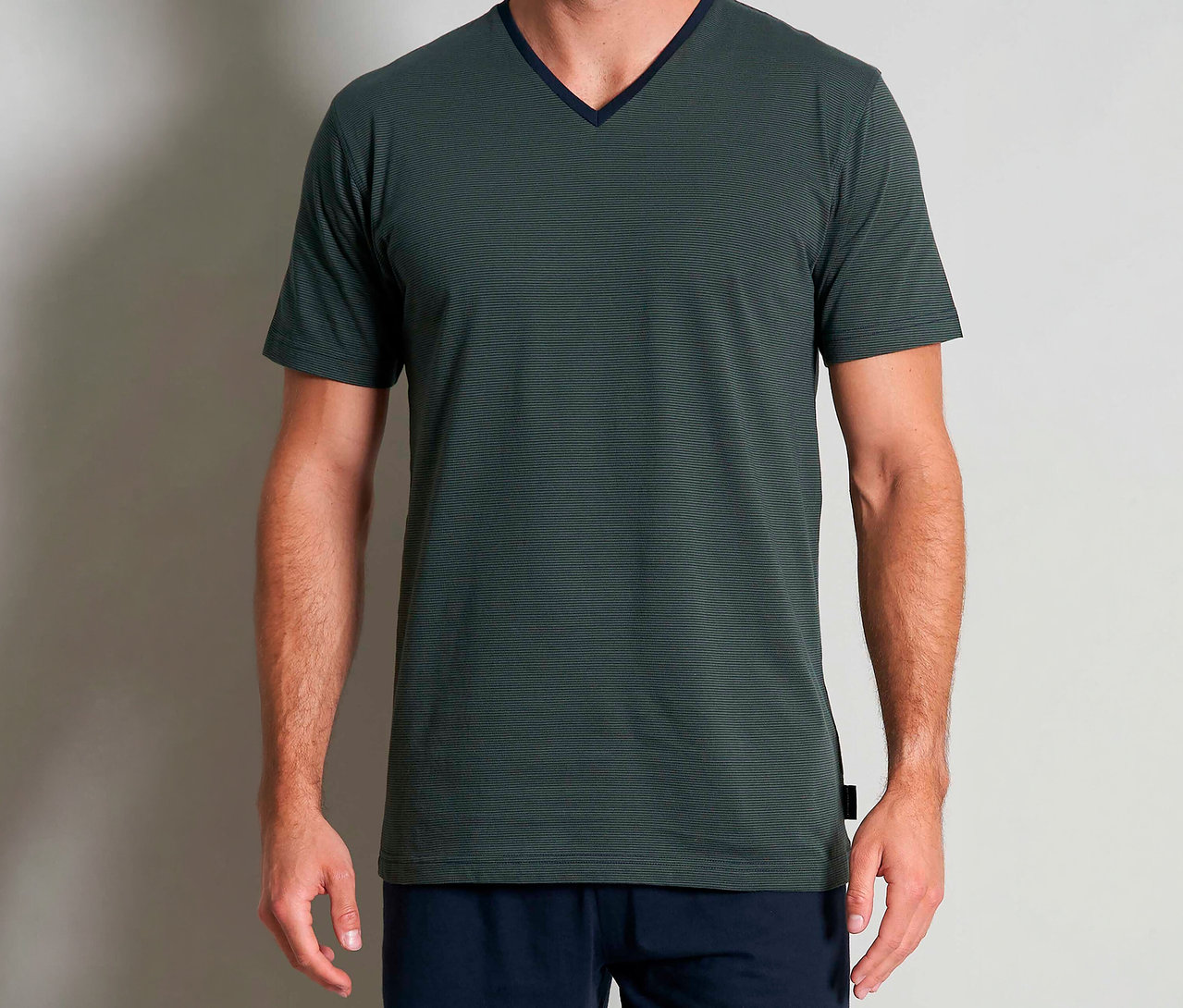 Férfi visel egy zöld Tom Tailor »Nevada« rövidnadrágos pizsamát V-nyakkivágással és rövid ujjakkal.