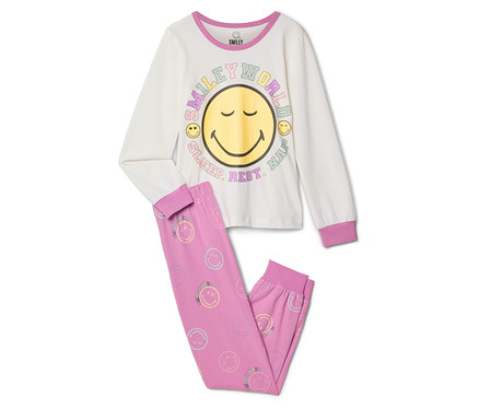 SMILEYWORLD® gyerekpizsama: Krémszínű, hosszú ujjú felső nagy sárga mosolygós arccal és „SMILEY WORLD SLEEP. REST. NAP.” felirattal, hozzá rózsaszín nadrág apró pasztell smiley arcokkal.