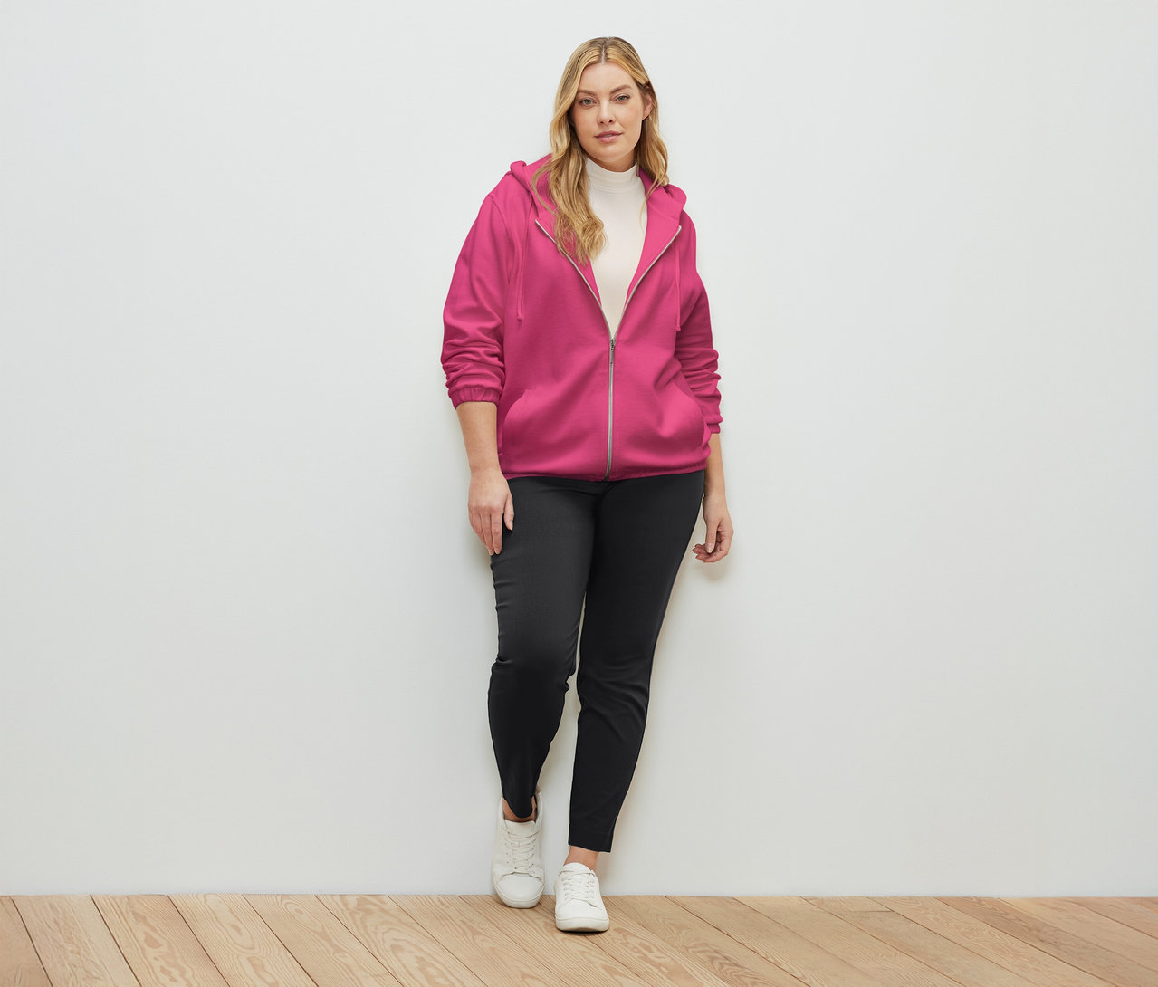 Nő visel fukszia színű szabadidőfelsőt.