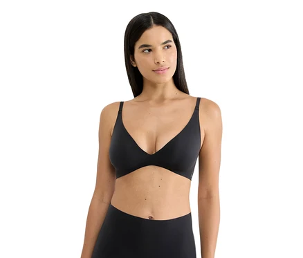Nő visel egy fekete sloggi ZERO FEEL PUSH-UP melltartót, oldalra nézve.